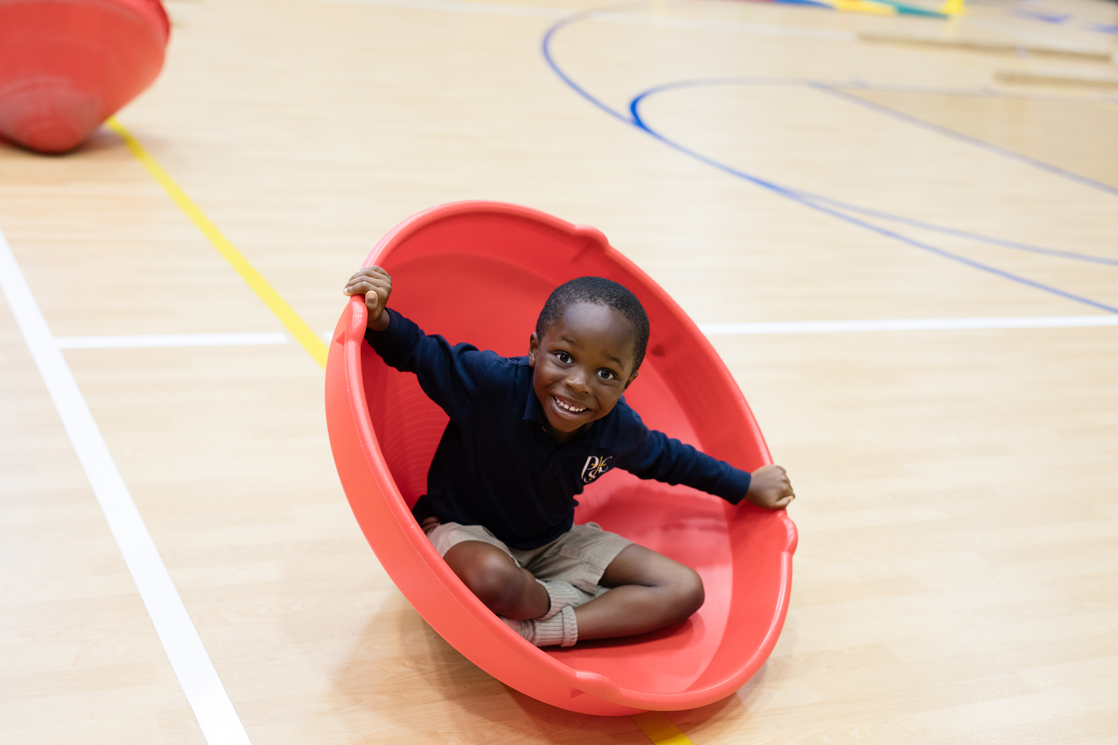 Boy student in a motor time development toy at Providence Classical School