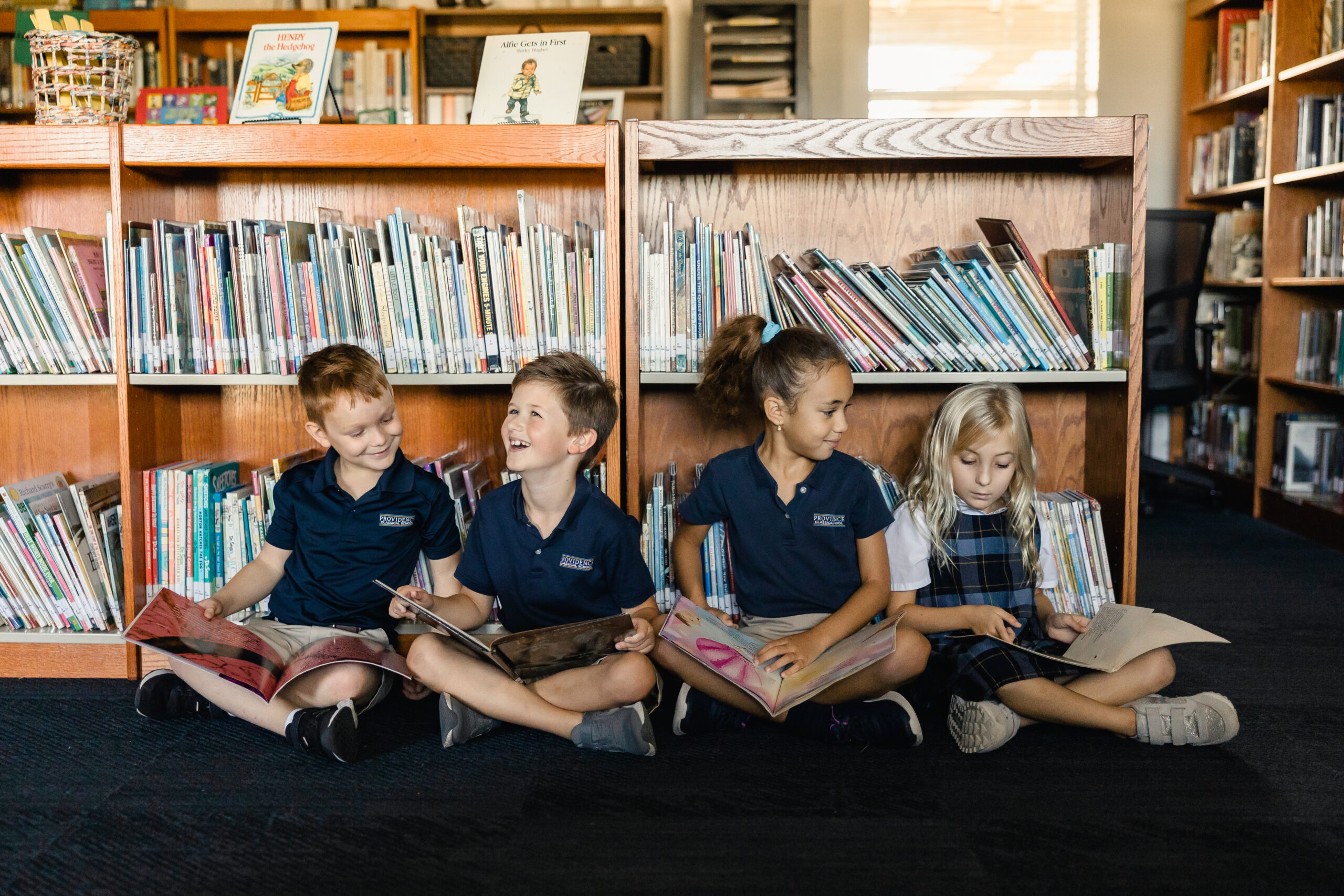 Elementary school students read books in the library at Providence Classical School
