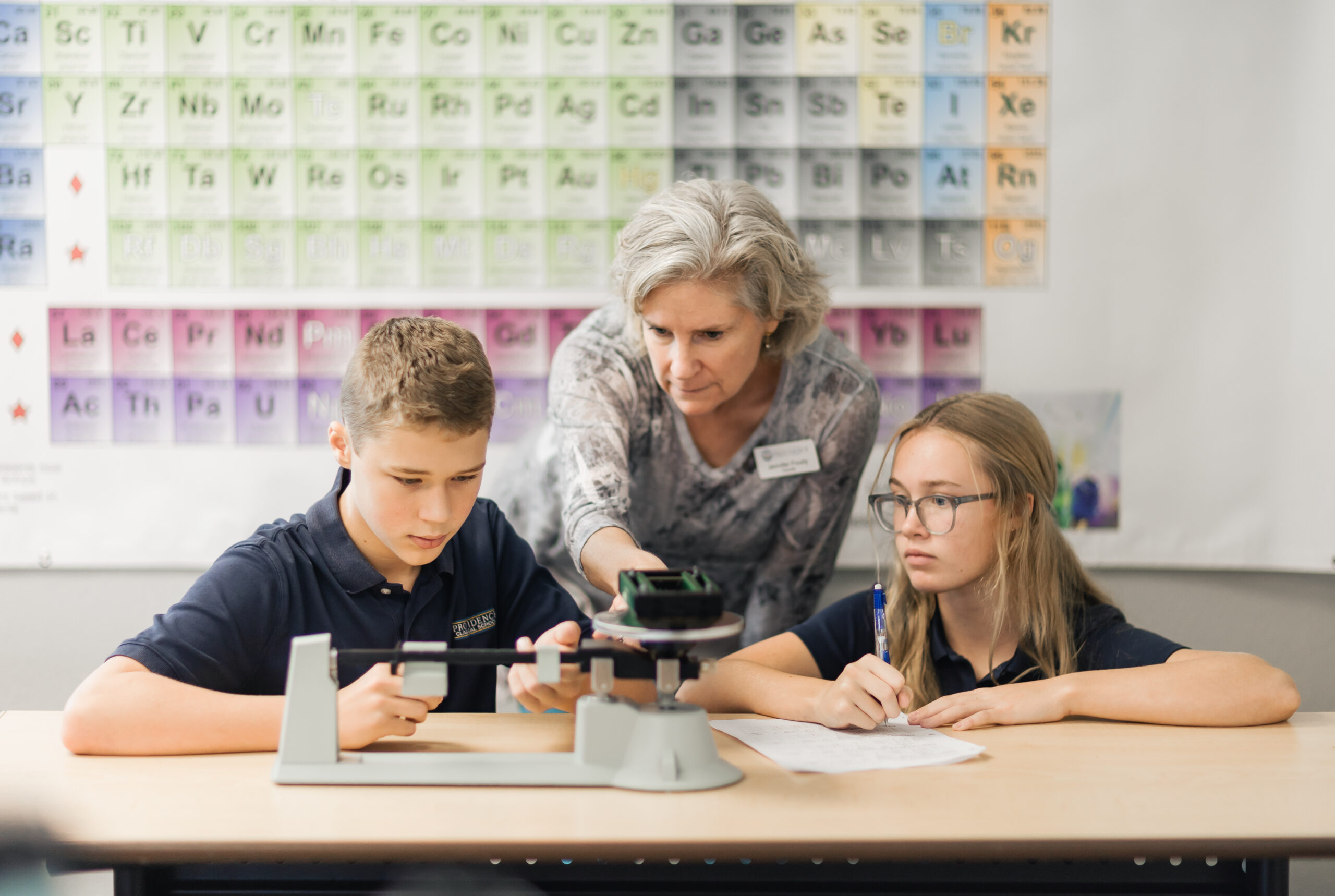 Dedicated PCS teacher guiding students in a classical Christian education setting.